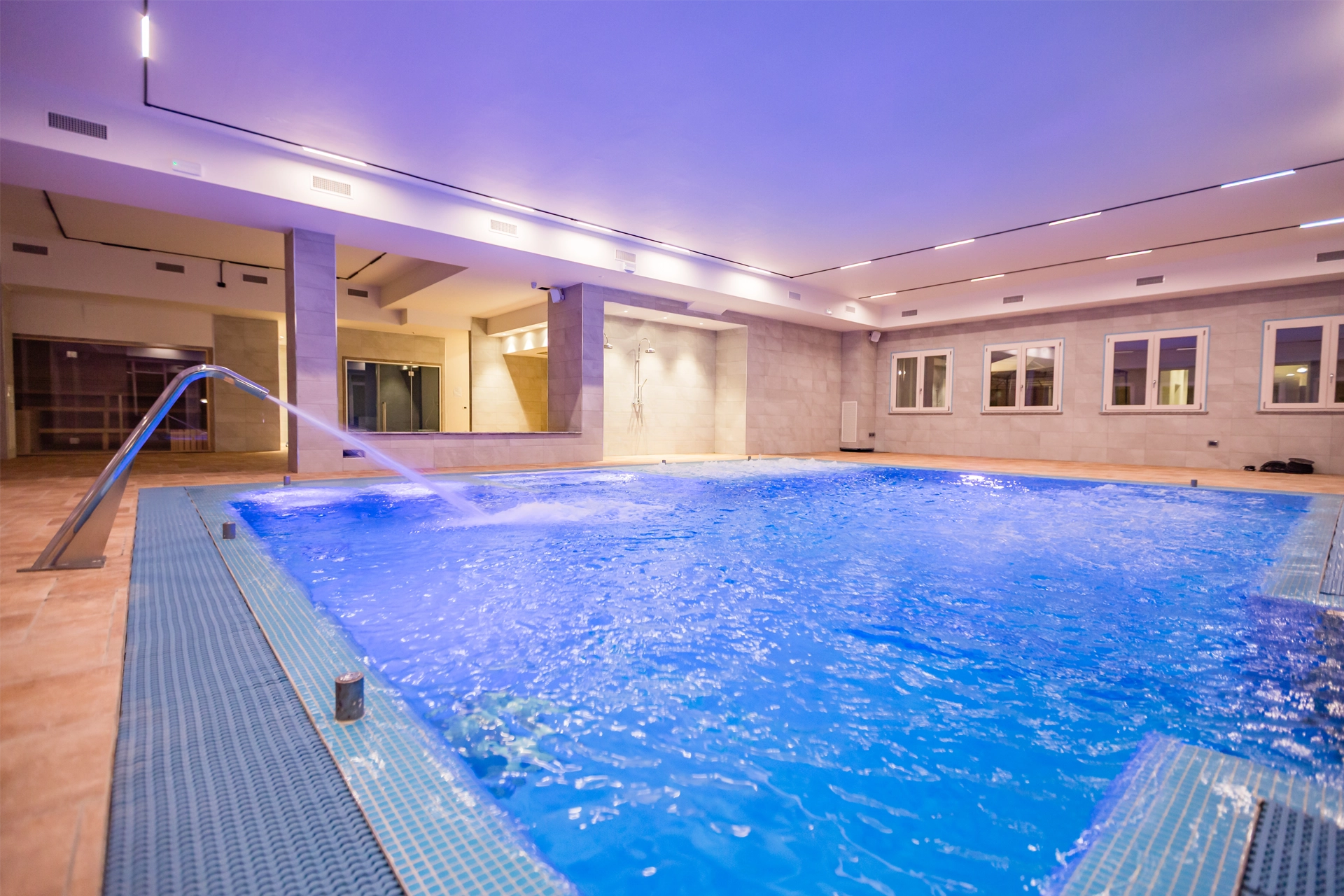 Grande piscina interna riscaldata con getti idromassaggio nella SPA di lusso della Tenuta Elisabetta in Maremma.